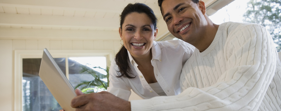 Man and woman smiling while using their laptop