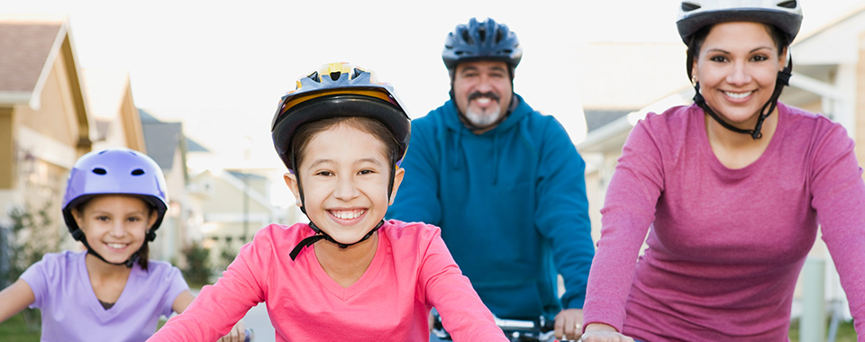 Smiling family riding bikes.